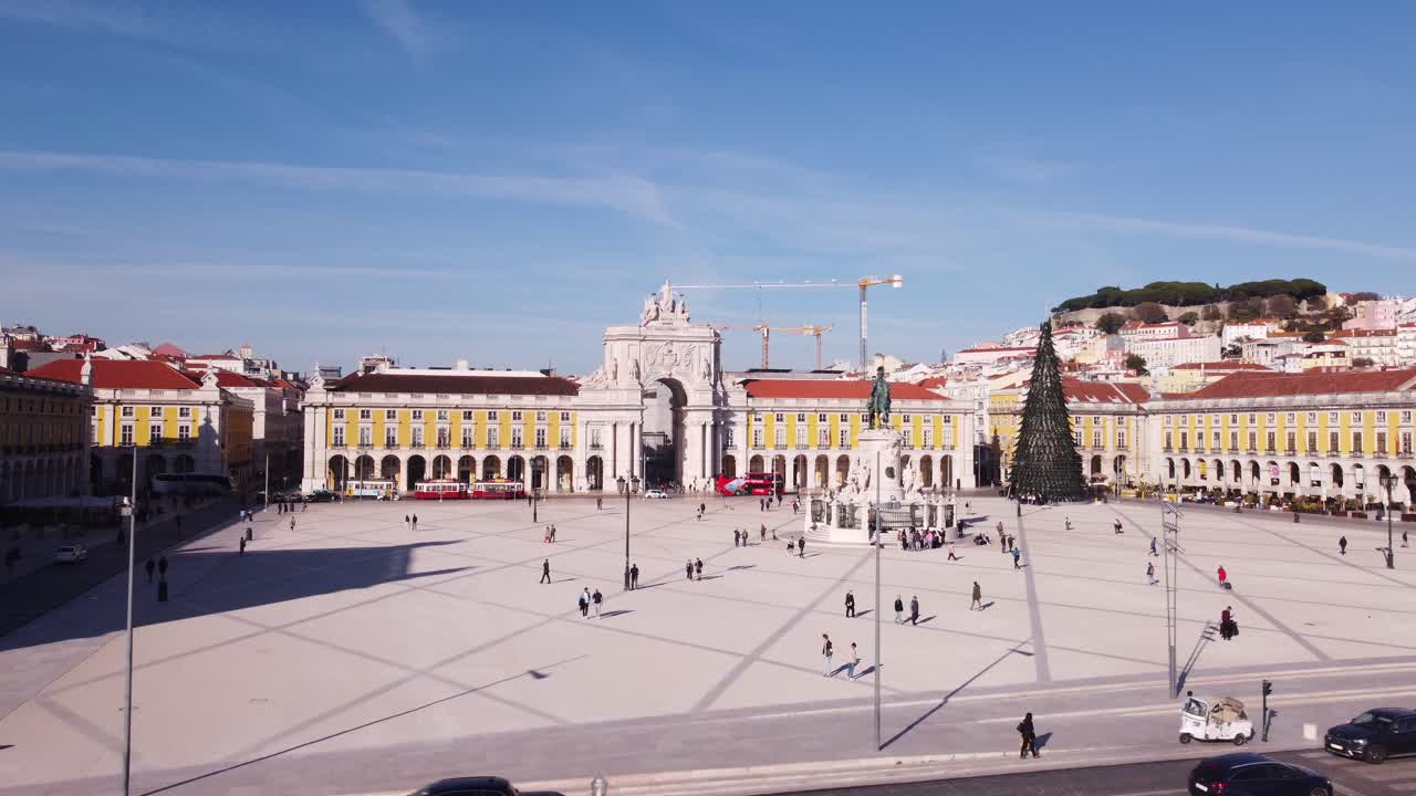 dron que se dirige hacia atrás a la bahía con foco en el arco da rua augusta mientras la playa de la ciudad aparece a la vista