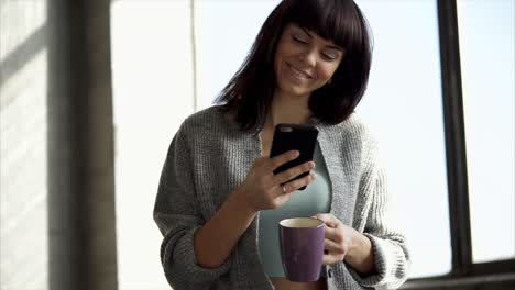 woman using phone while enjoying coffee