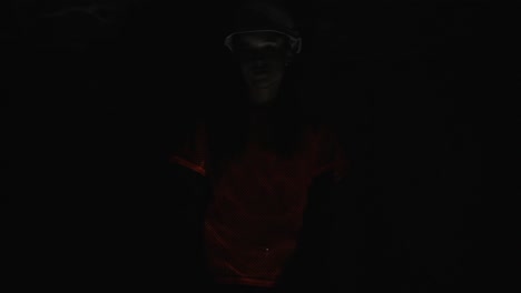 woman in a helmet and red shirt in a dark room