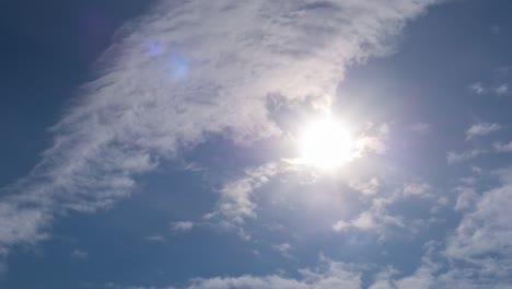 low angle views blue sky cloud sun background. timelapse of skycaps on a sunny day. white cumulus fluffy clouds cover sunrays sun flare in clear weather. b-roll footage panoramic view nature.