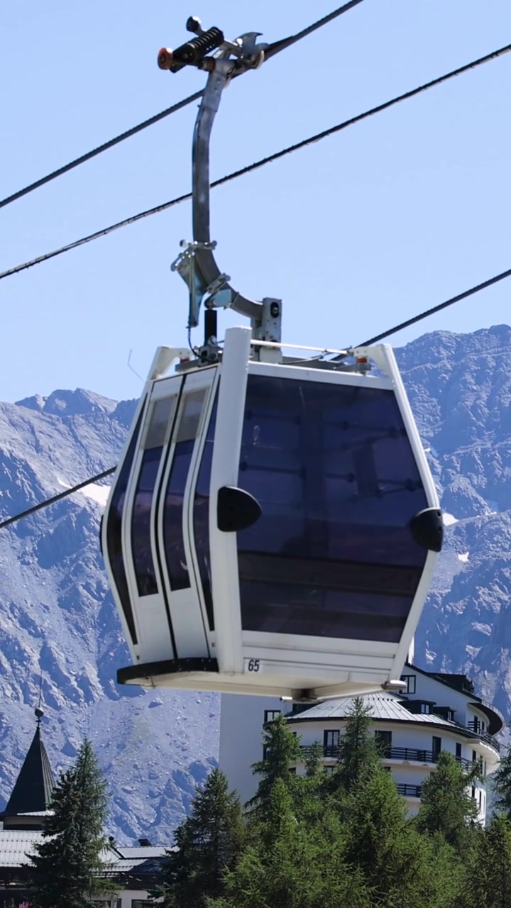 Funivia che attraversa un paesaggio montano suggestivo con un hotel