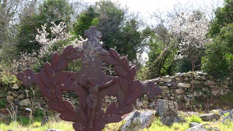 Antiguo-Cementerio-Irlandés-De-Hambruna,-Cruz-De-Metal-En-Medio-De-Una-Antigua-Iglesia-En-Ruinas-En-Una-Cálida-Tarde-De-Primavera
