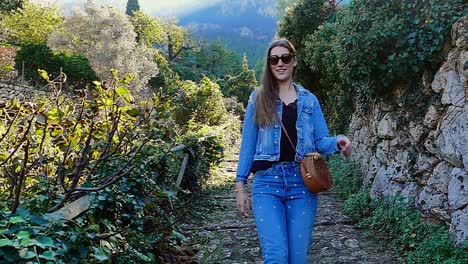 slow motion (120fps): happy young beautiful lady walks downhill in mallorca, spain