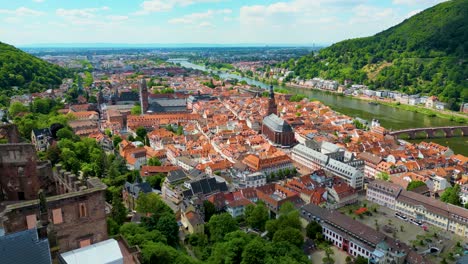 4k aerial drone video of the ruins of the historic castle on königstuhl hill overlooking heidelberg, germany on the neckar river