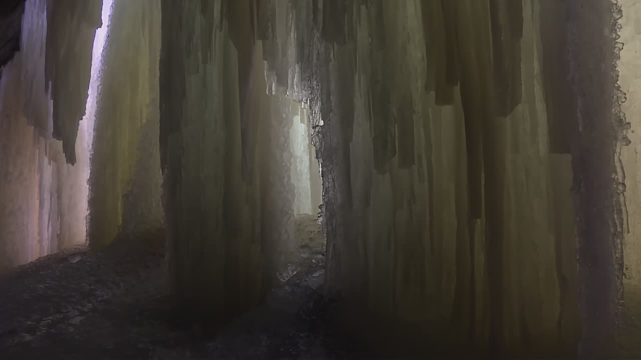 Thick vertical ice waterfall wall inside Eben Ice Caves, Michigan, USA. Tilt down view