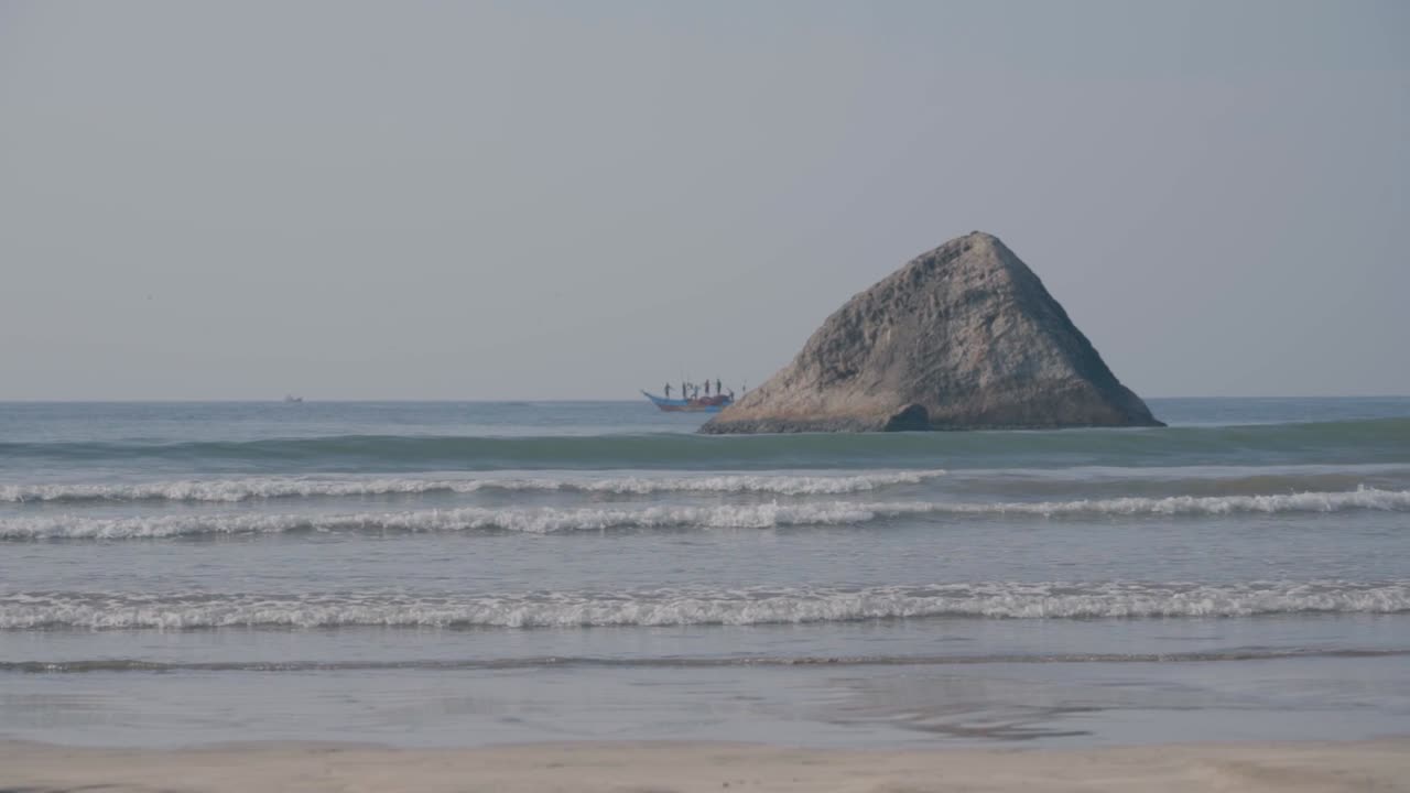 푸른 바다 를 항해 하는 어부 들 이 스리랑카 의 웰리가마 해변 에 있는 바위 형성 을 드러낸다