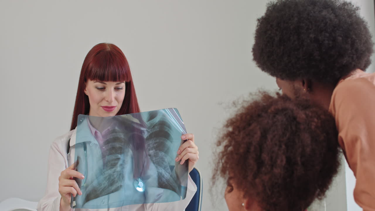 Una pediatra che tiene in mano una radiografia polmonare: la dottoressa esamina la radiografia di una bambina malata