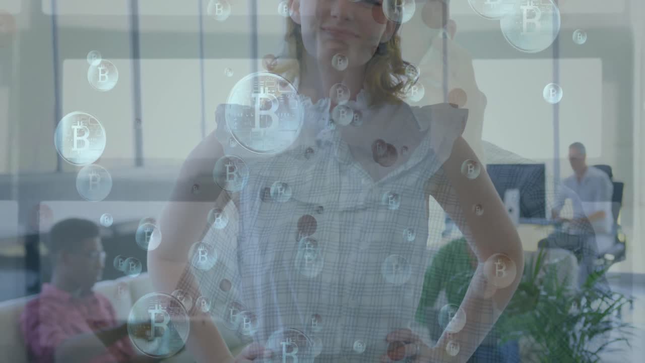 animación de bitcoins flotando sobre feliz mujer de negocios caucásica en la oficina