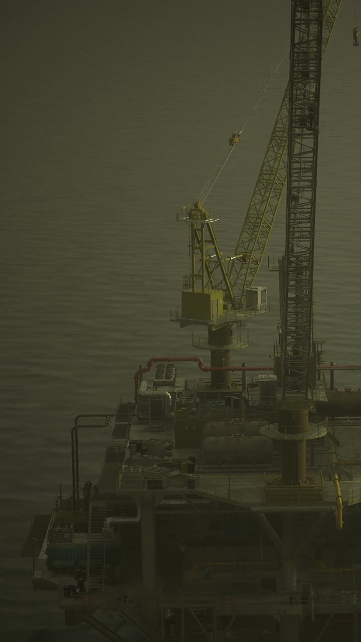 Kran på en offshore platform i skumringen over vandet.