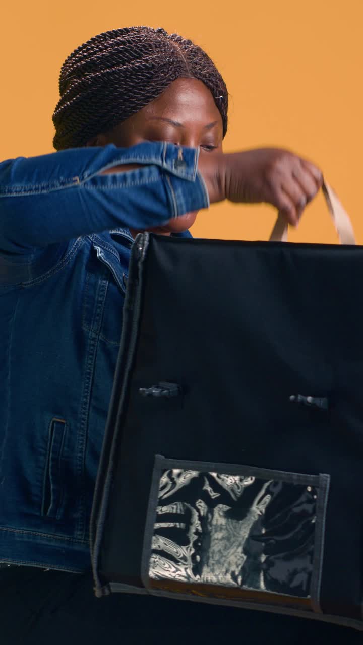 Food delivery person packing food in delivery bag