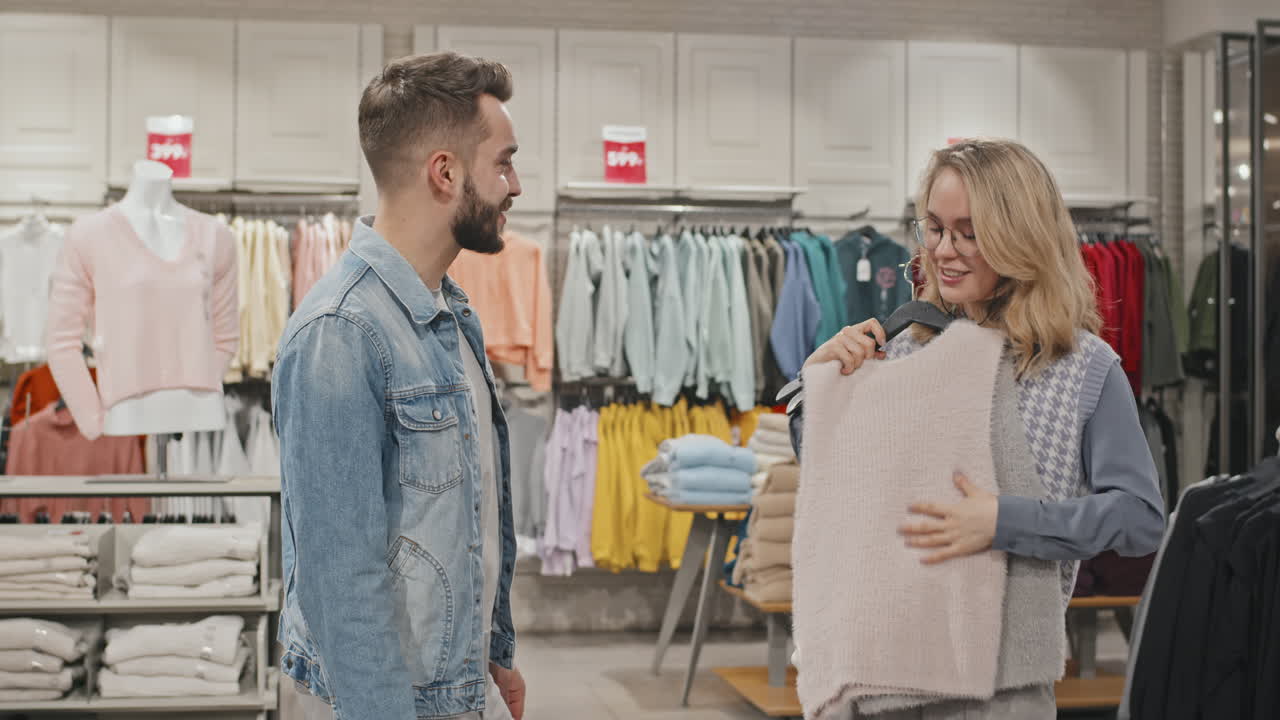 Giovane donna con il fidanzato che compra vestiti