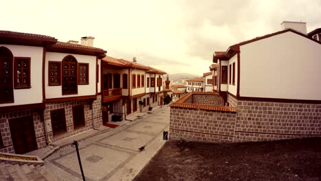 small street of old ankara with white houses cat walk cloudy day