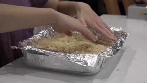 A-young-girl-prepares-the-crust-in-a-baking-tray-for-making-millionaire-shortbread-cookies-2