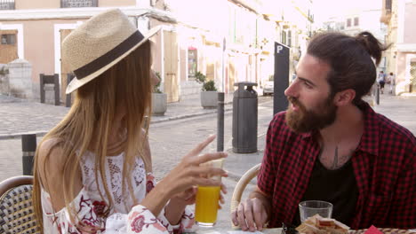 couple on vacation reading a guidebook outside a cafe, shot on r3d