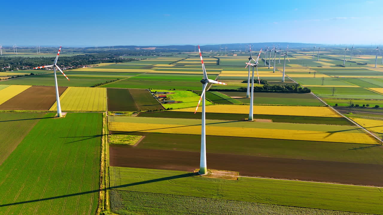 Wind rotates the blades of the wind turbines. Aerial perspective on the wind farms in the beautiful countryside.