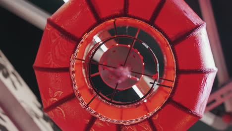 a dramatic upward close-up of a glowing red chinese lantern, capturing its intricate patterns, soft illumination, and circular frame, evoking a festive and cultural ambiance