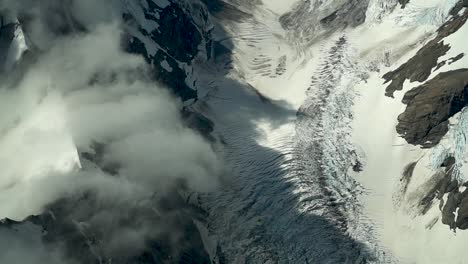 SLOWMO---Hooker-glacier,-Southern-Alps,-New-Zealand-with-clouds,-snow-and-rocky-mountains-from-scenic-airplane-flight