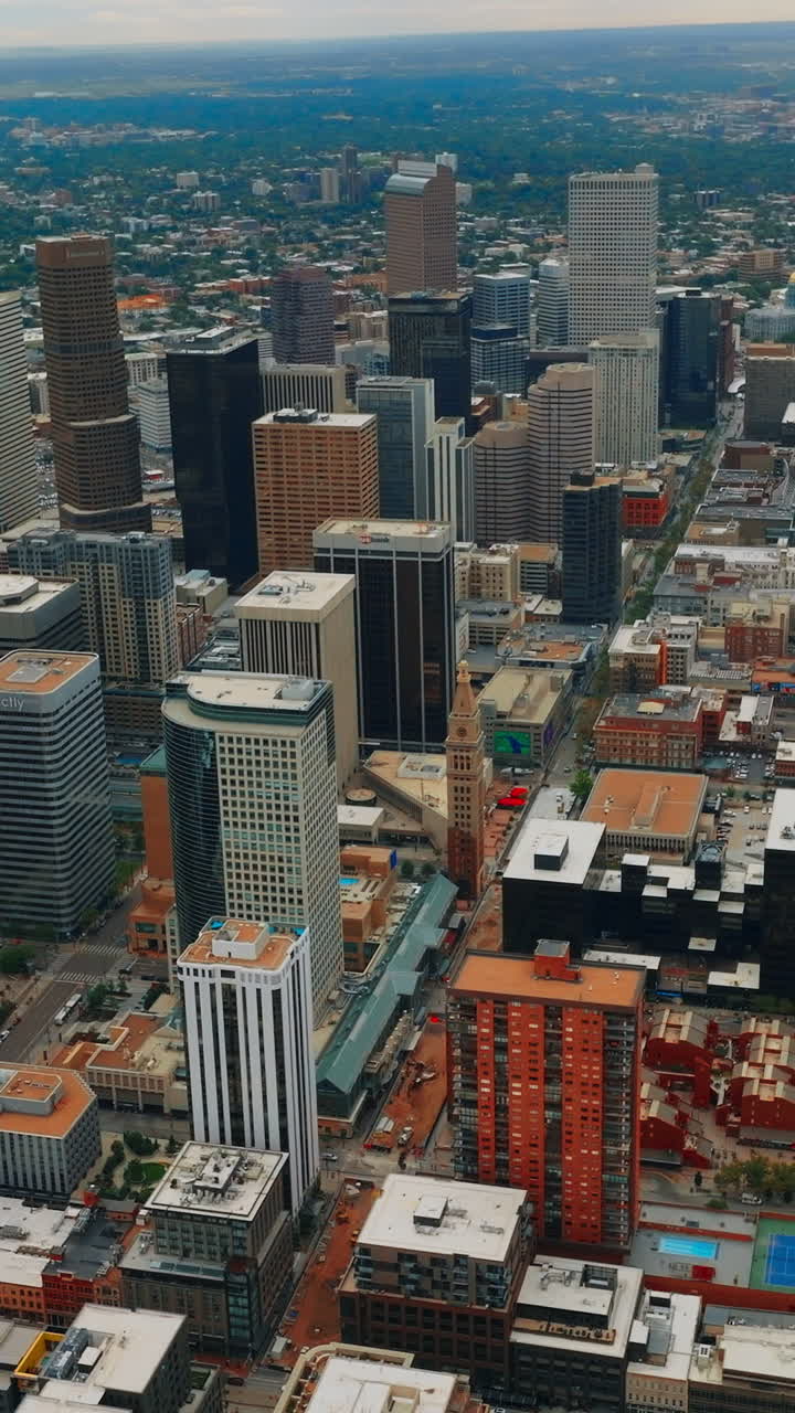 Gorgeous view of skyscrapers in the downtown of beautiful Denver, Colorado, USA. Metropolis centre at backdrop of green city at daytime from bird's eye view. Vertical video