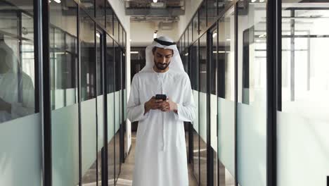 handsome man and woman with traditional clothes working in an office of dubai