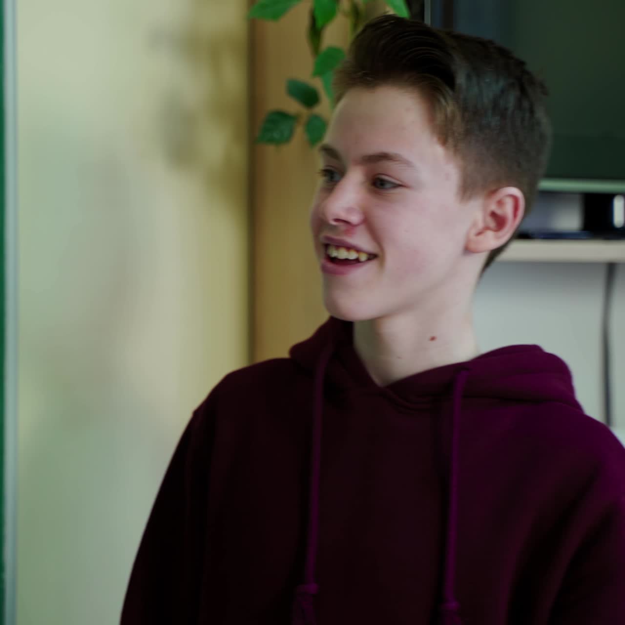 Portrait of a teenage boy at school. Smart school boy standing near the blackboard and answering questions. Education at school.