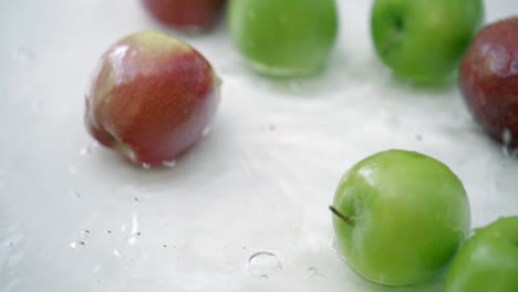 slomo de manzanas en agua sobre fondo blanco