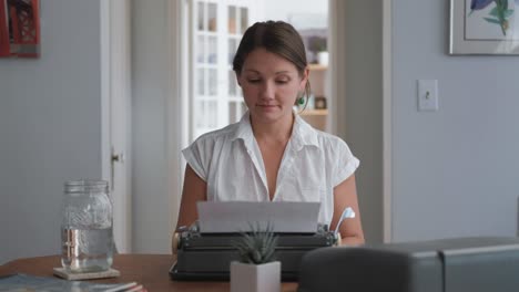 Wide-shot-caucasian-woman-typing-on-typewriter