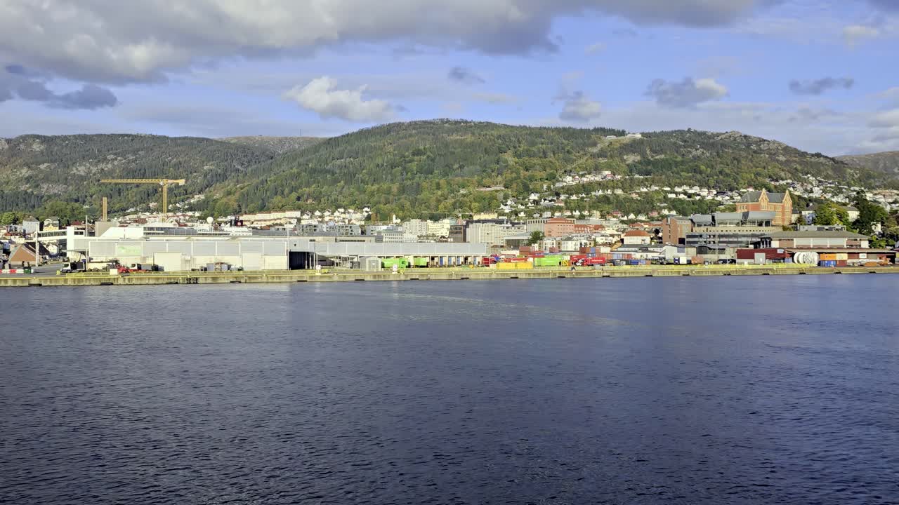View from sea showing Posten Bring terminal with green containers and company logos in Bergen harbor