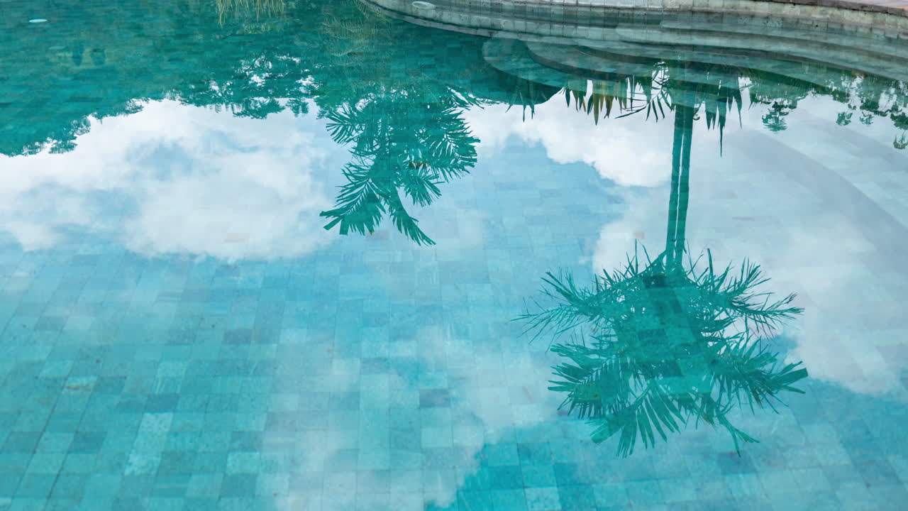 timelapse of luxury swimming pool set with reflections of clouds in the water
