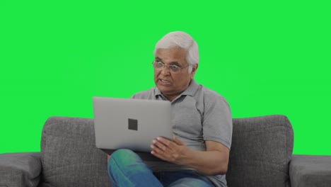 Anciano-Indio-Enojado-Gritando-En-Videollamada-En-La-Pantalla-Verde-De-Una-Computadora-Portátil