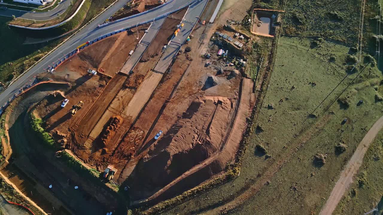 Drone reveals a full view of Canberra’s highway construction zone with the path of the new road cut through the earth.