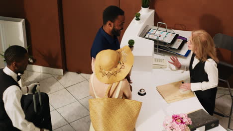 front desk worker welcoming tourists