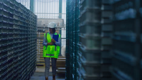 storage woman worker noting delivery details checking shipment pallets thinking