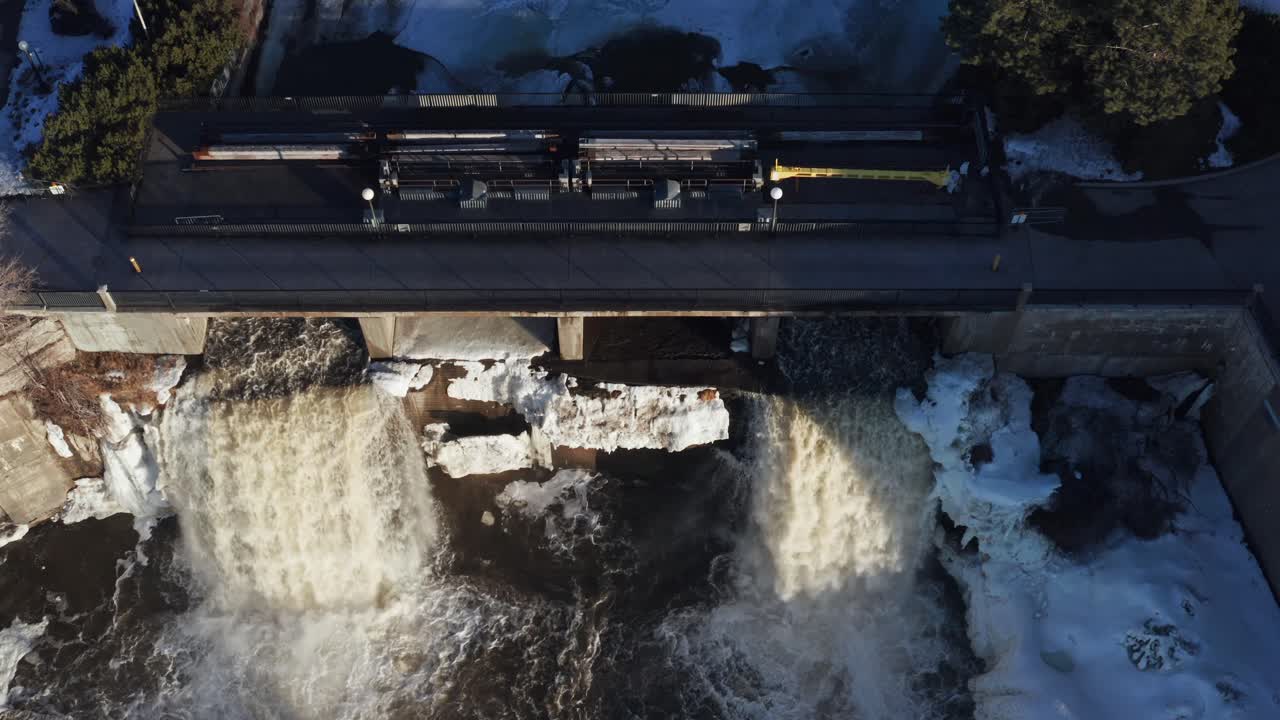 Drone video looking down at Rideau Falls in Ottawa Ontario Canada during spring while ice is beginning to break up