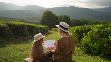 mother and daughter drawing in a tea plantation