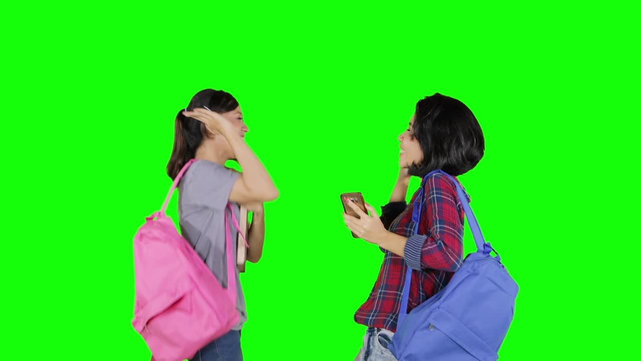 Two successful students with cellphone in studio