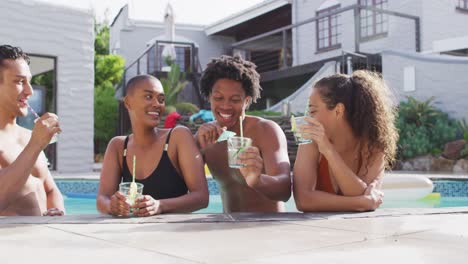 Grupo-De-Amigos-Diversos,-Hombres-Y-Mujeres,-Con-Bebidas-Riéndose-En-La-Piscina