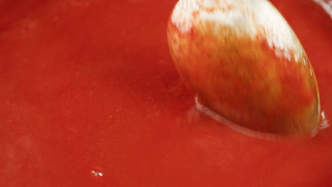 Chicken in tomato sauce is boiling on a frying pan with spices. Cooking tomato sauce curry with chicken fillet. Traditional Italian Mexican Asian dish. High quality studio shot for cafe, restaurant close up.