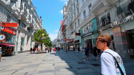 vienna, austria - june 9, 2025: exploring the shopping streets of wien. tourists stroll through a vibrant street in wien, austria, enjoying shops and the lively atmosphere on a sunny day