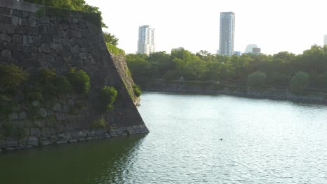 the inner moat and stone wall around osaka castle in chūō-ku, osaka, japan. wide shot