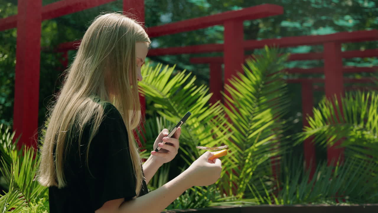 Woman taking picture of butterfly in nature