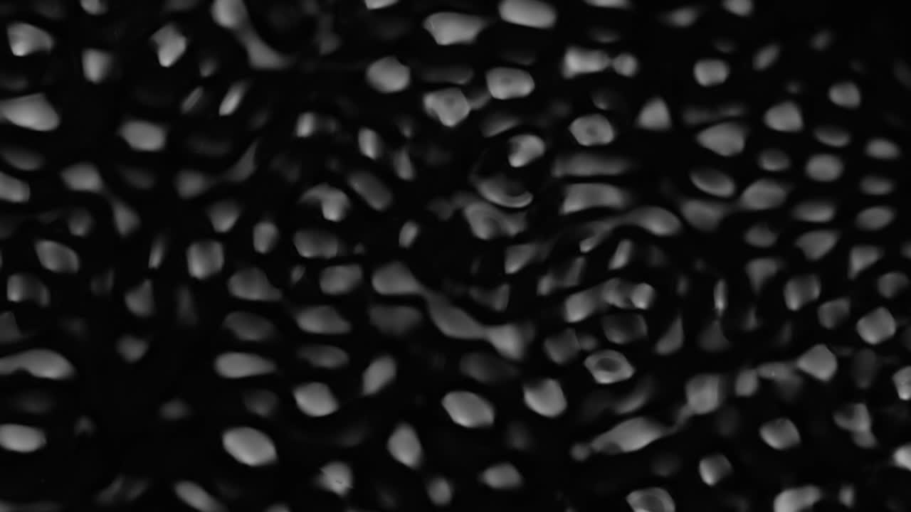 액체의 표면에 스플래시와 물방울, 추상적인 검은 배경 물 진동, 4k 느린 동작, 100fps, 42bits, 10bits