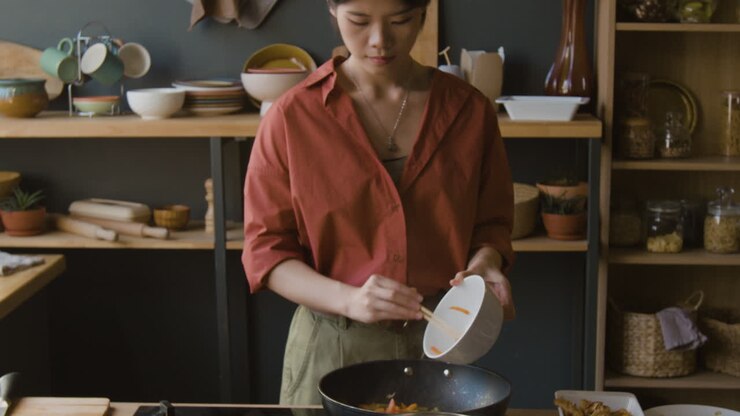Donna che Cucina Stir-Fry nella Cucina di Casa