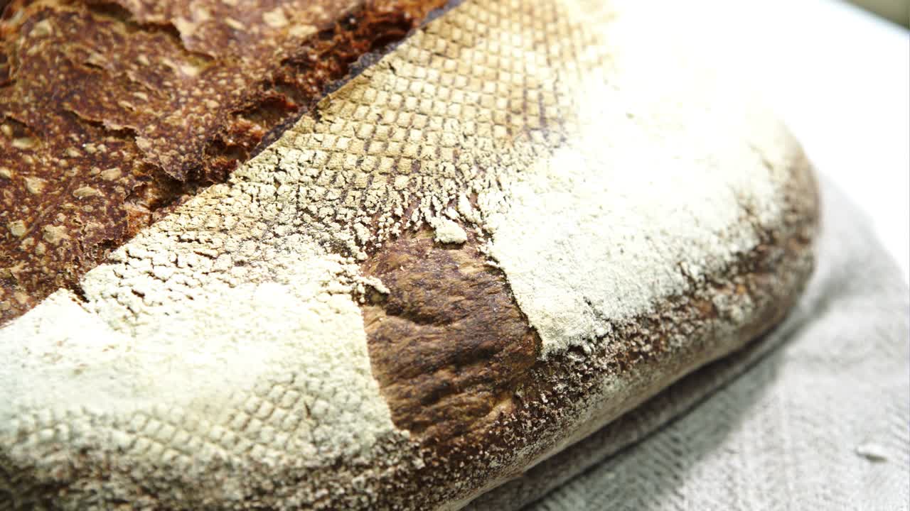 A delicious freshly baked rye bread ruddy on a table with a towel