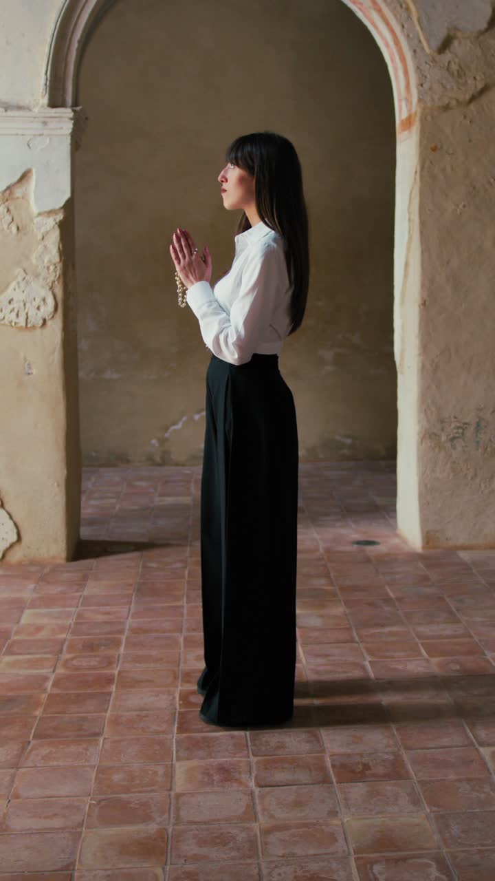 Woman Standing Still In The Middle Of An Old Church And Praying