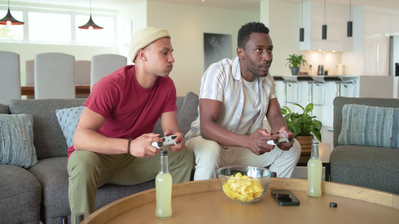 Diverse male friends exchanging smiles before starting gaming with controllers for fun in lounge