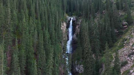 aerial shot barskoon waterfall in fairy tale canyon in kyrgyzstan, wide descending drone footage