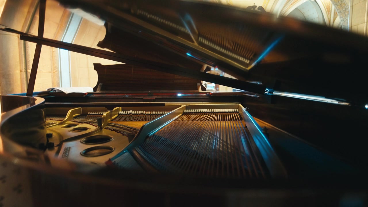 The intricate mechanics inside a piano come to life as a pianist's hands dance across the keys, producing harmonious melodies.