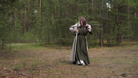 girl in medieval dress dances and friend holds sword by neck