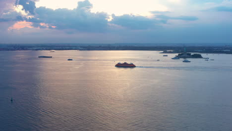 la panorámica aérea lenta sigue al ferry de staten island a medida que pasa por el puerto de nueva york