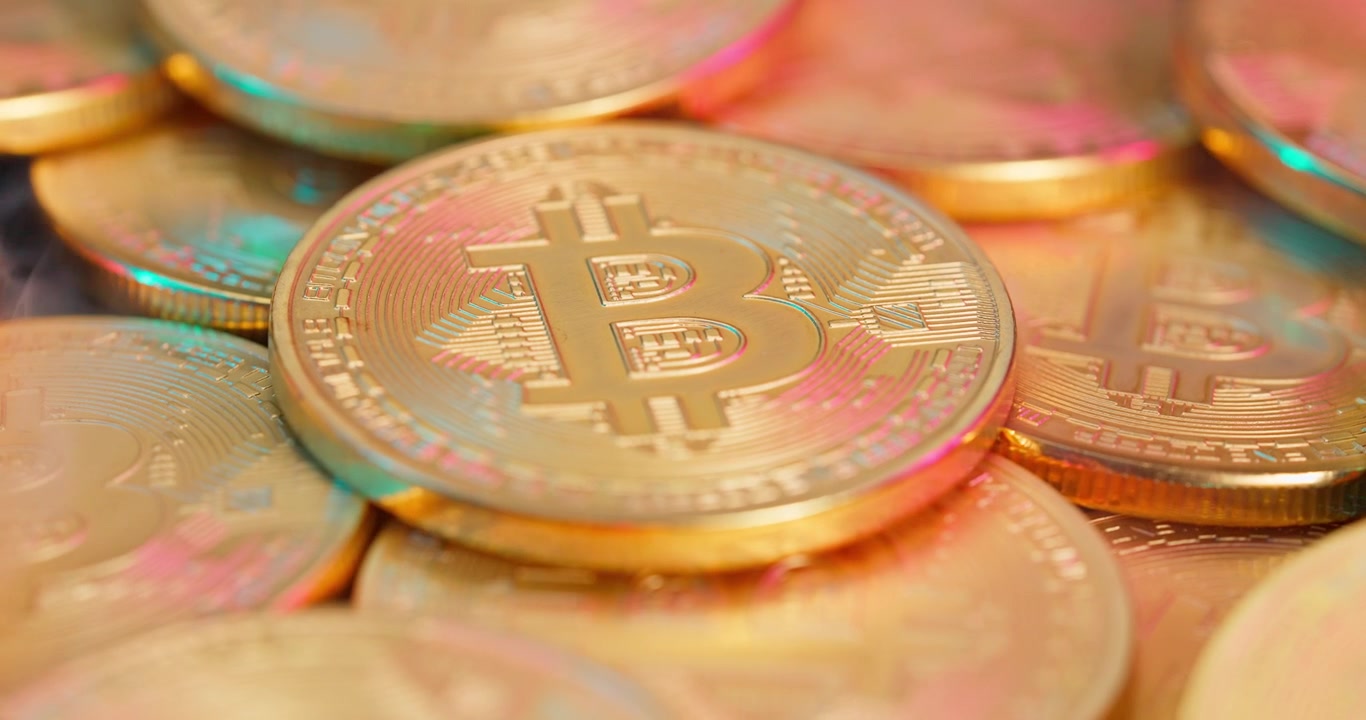 Moneta Bitcoin dorata con riflessi di luce colorati